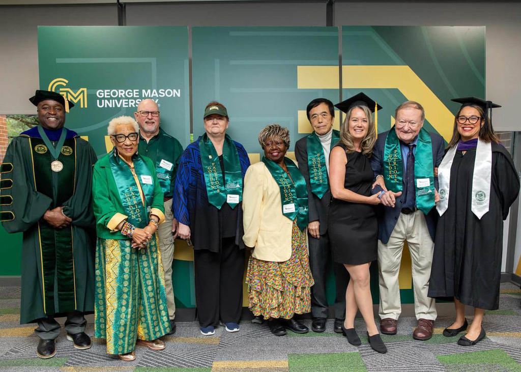 Five members of the Golden Patriots, George Mason alumni who graduated 50 years or more ago, pose with President Washington and current students