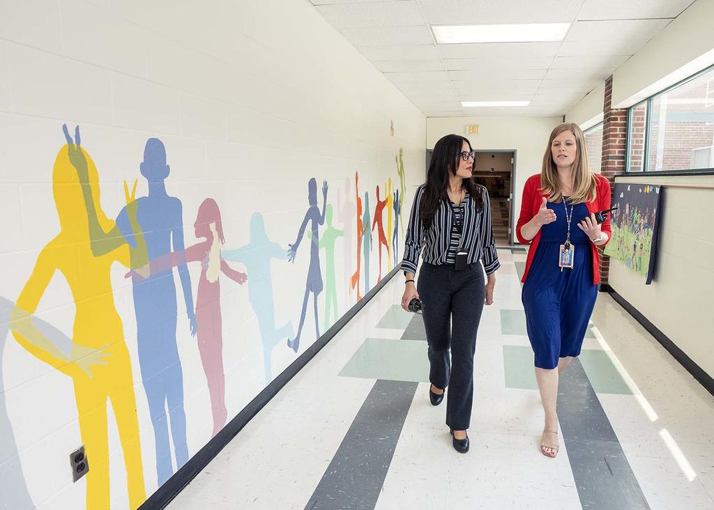 Liza Burrell-Aldana (pictured on left), PhD, principal of Mount Vernon Community School in Del Ray walks the halls during school